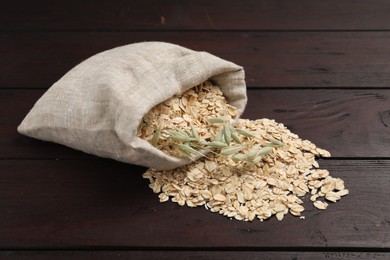 Overturned sack with oatmeal and florets on dark wooden table