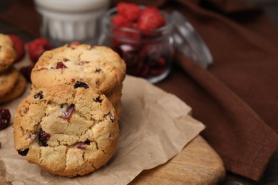 Photo of Cookies with freeze dried fruits on wooden board, closeup. Space for text