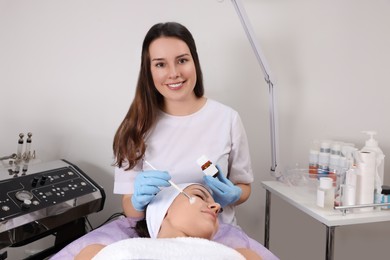 Photo of Young woman undergoing cosmetic procedure in beauty salon