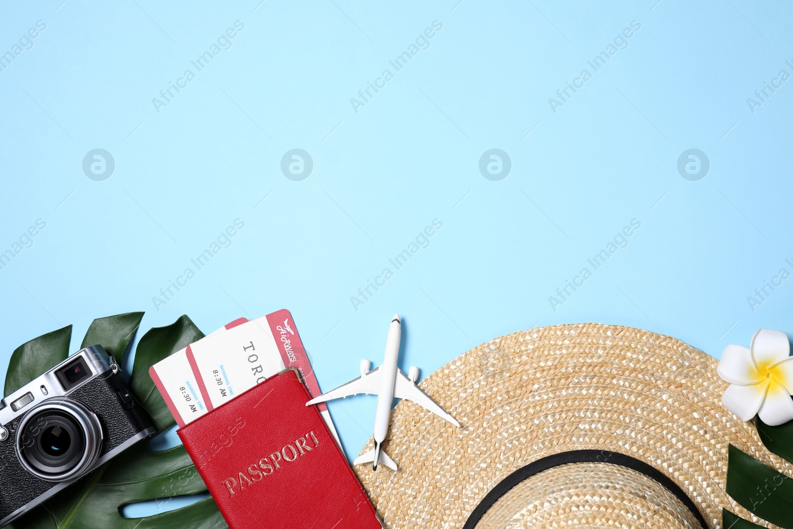 Photo of Flat lay composition with passport and camera on light blue background. Space for text