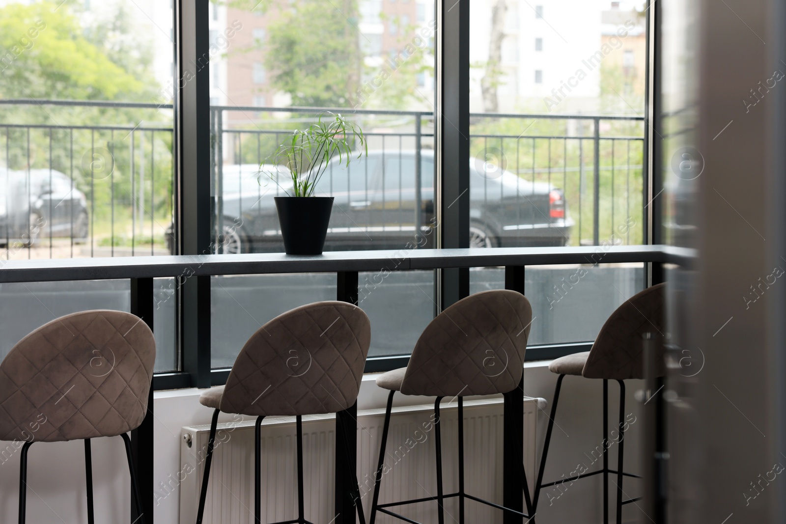 Photo of Table and bar stools near window in hostel dining room