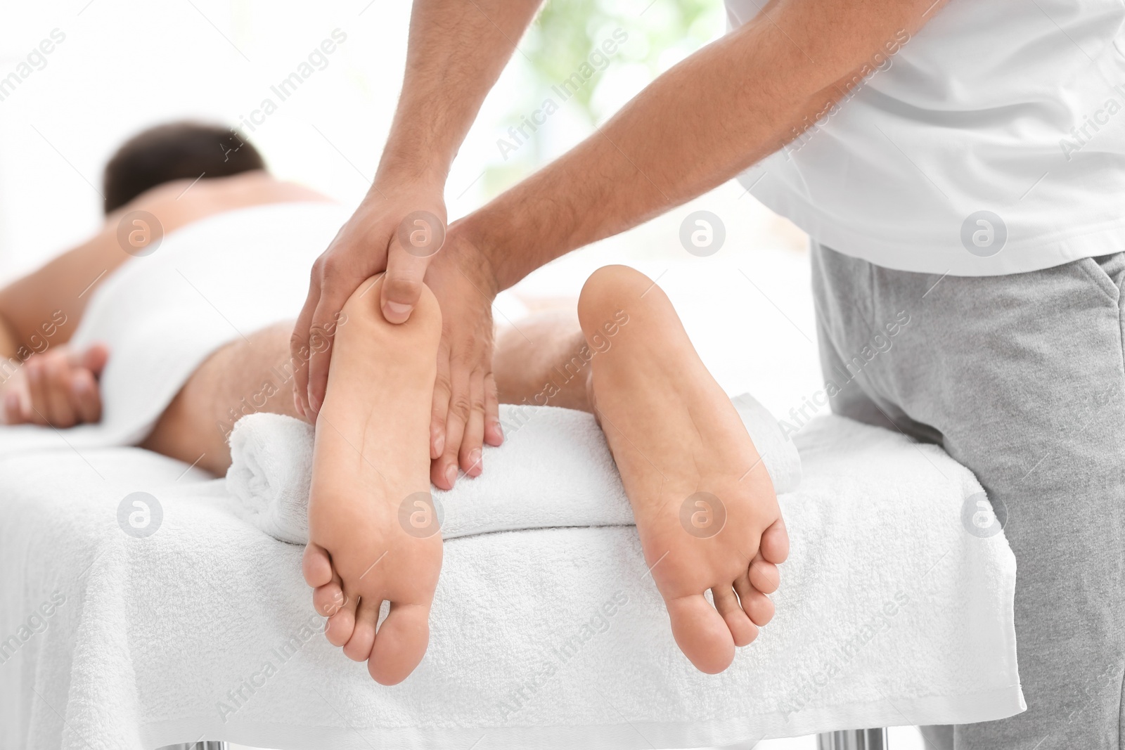 Photo of Young woman receiving massage in salon, closeup