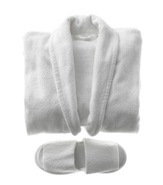 Photo of Clean folded bathrobe and slippers isolated on white, top view