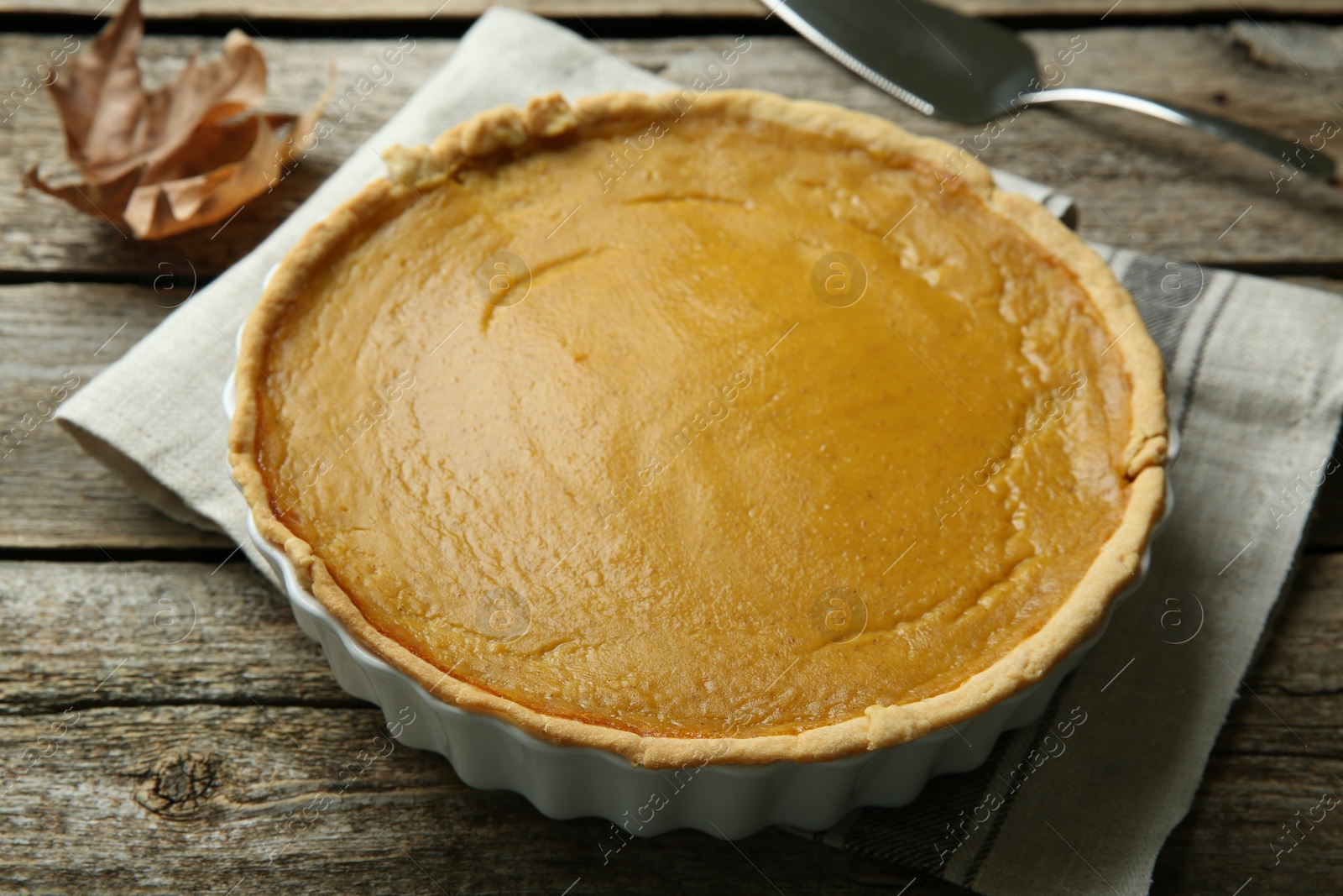 Photo of Delicious fresh pumpkin pie on wooden table