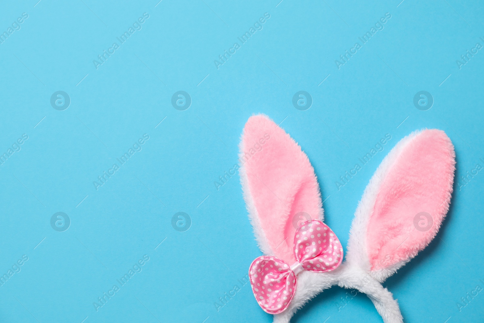 Photo of Funny headband with Easter bunny ears on color background, top view. Space for text