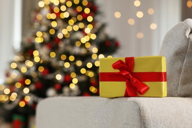 Photo of Beautiful gift box in room decorated for Christmas. Bokeh effect