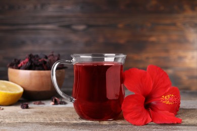 Delicious hibiscus tea and beautiful flower on wooden table