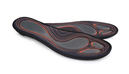 Photo of Orthopedic insoles for shoes on white background