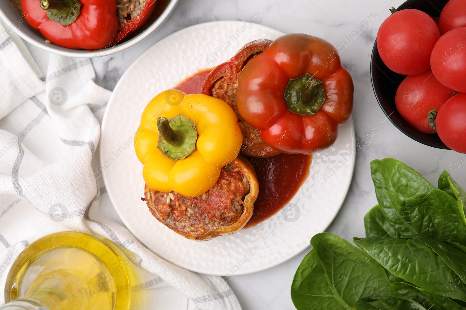 Photo of Delicious stuffed bell peppers served on white marble table, flat lay