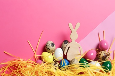 Flat lay composition of Easter bunny figure and eggs on color background, space for text