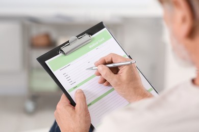 Patient filling his medical card in clinic, closeup