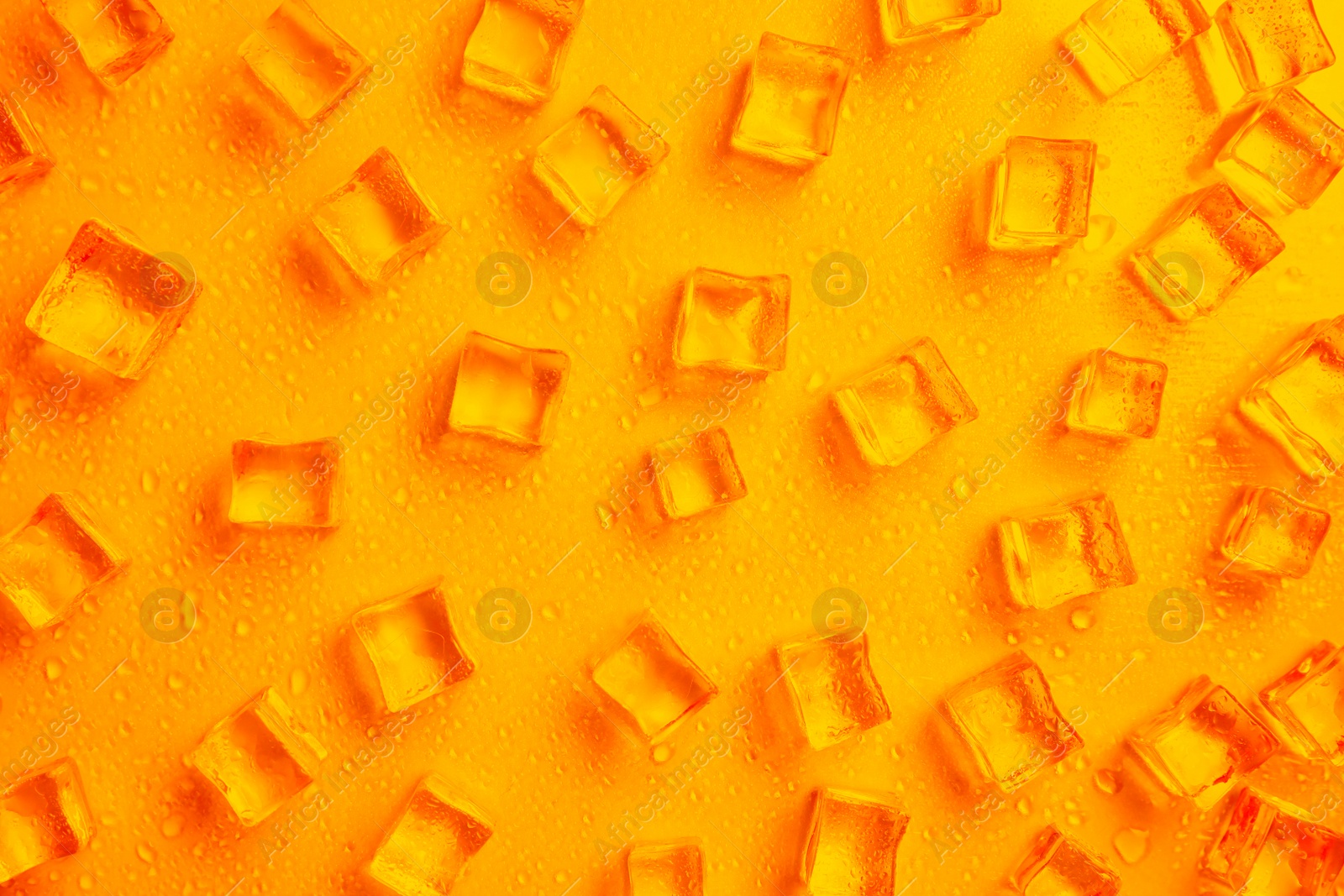 Image of Cold ice and water drops on orange background, flat lay. Ingredient for refreshing drink