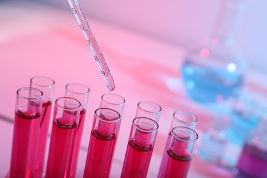 Photo of Dripping reagent into test tube with red liquid, closeup. Laboratory analysis