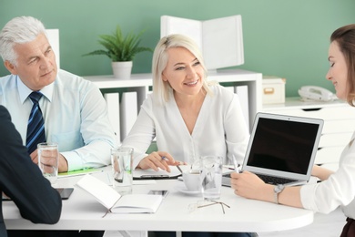 Photo of Group of people discussing ideas at table in office. Consulting service concept