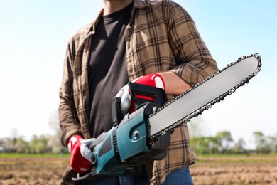 Man with modern saw on sunny day, closeup