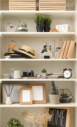 Photo of White shelving unit with photo frames and different decorative elements
