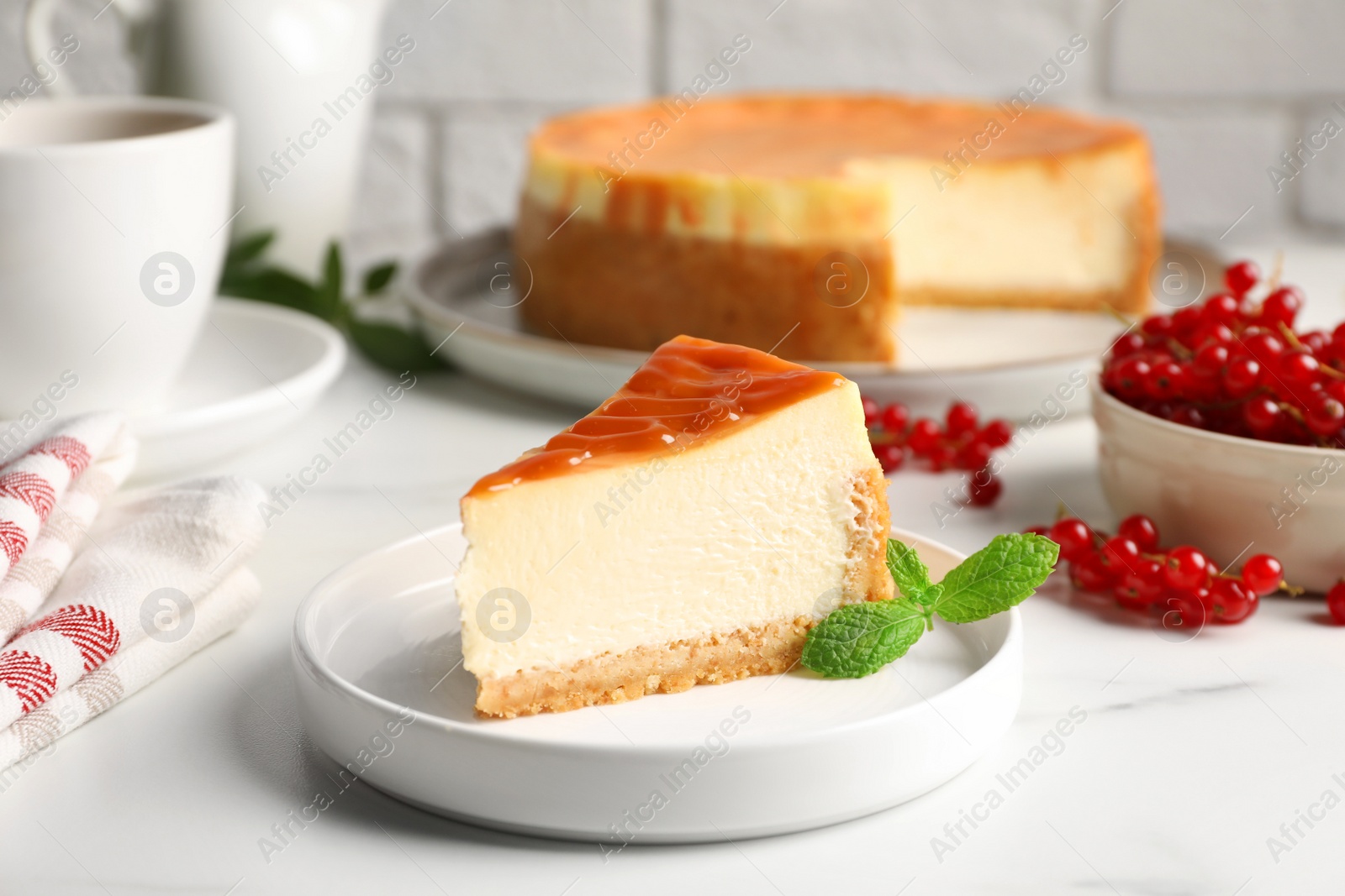 Photo of Piece of delicious caramel cheesecake served on white marble table