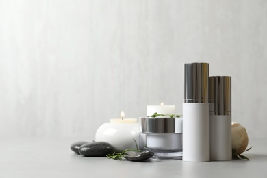 Composition with cosmetic products on light grey stone table. Space for text