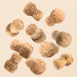 Image of Many corks of sparkling wine bottles falling on light background