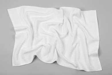 Crumpled white beach towel on light grey background, top view