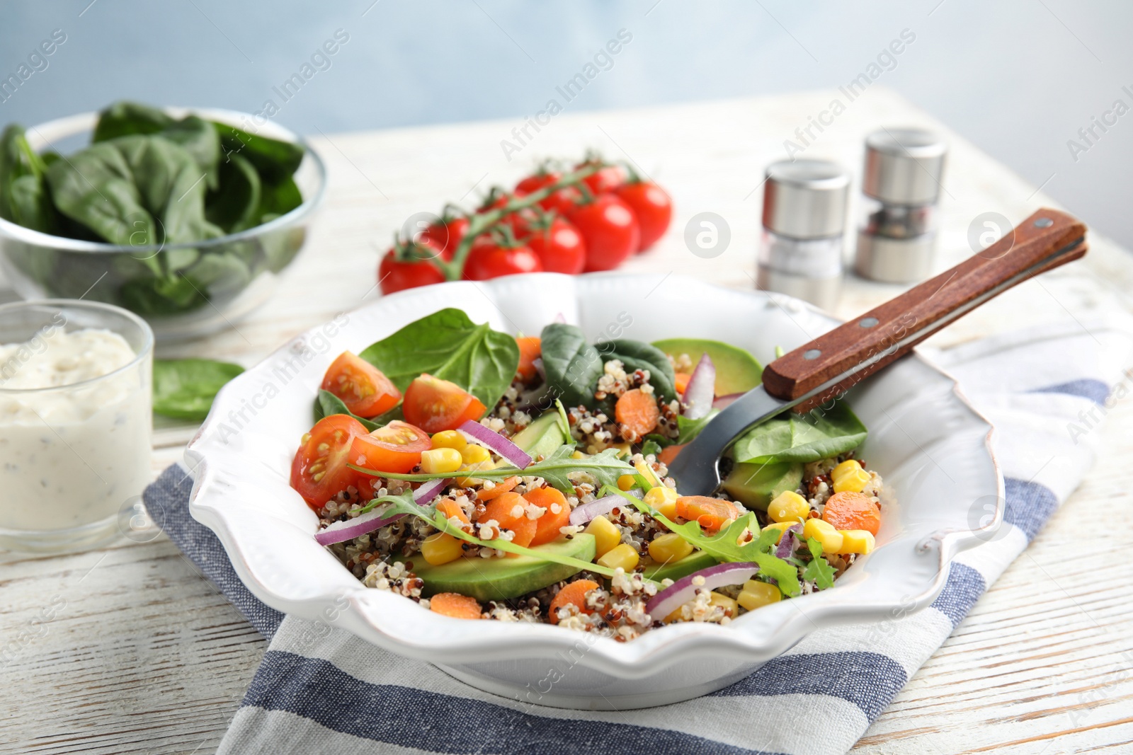 Photo of Healthy quinoa salad with vegetables in plate on table