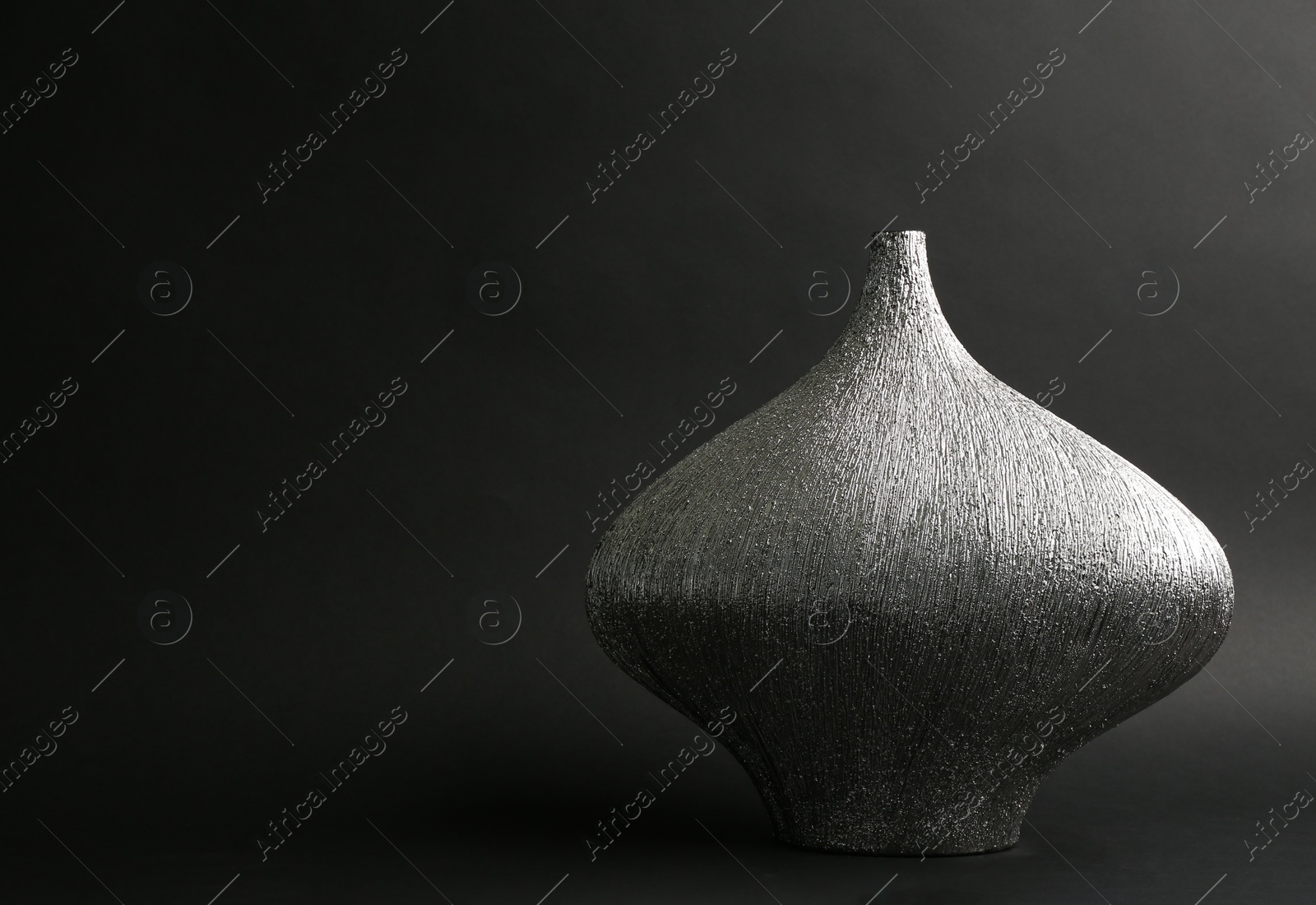 Photo of Stylish silver ceramic vase on black background, space for text