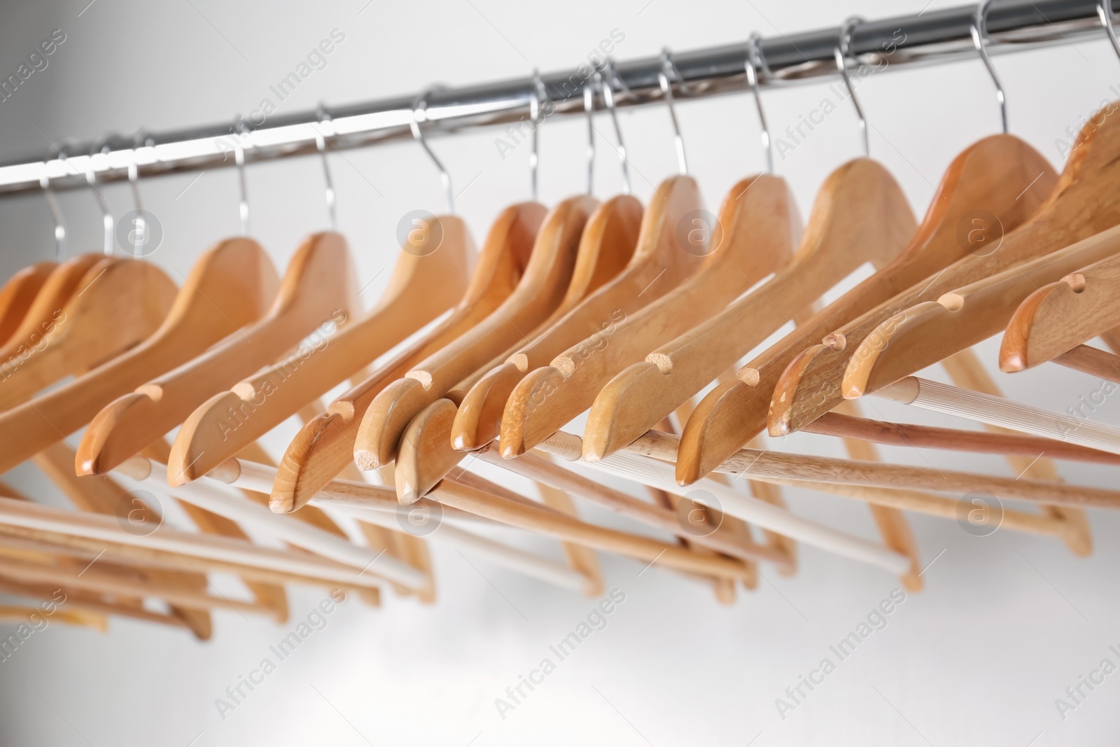 Photo of Clothes rail with wooden hangers on white background