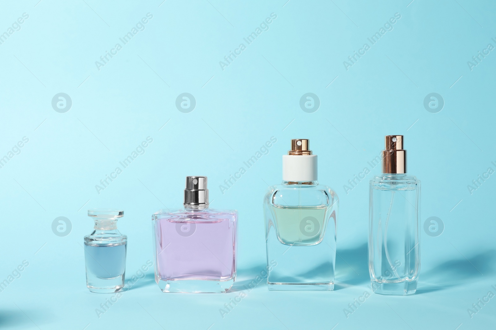 Photo of Bottles of perfume on color background