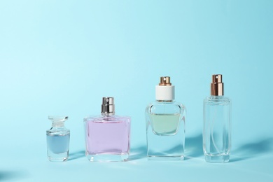 Bottles of perfume on color background