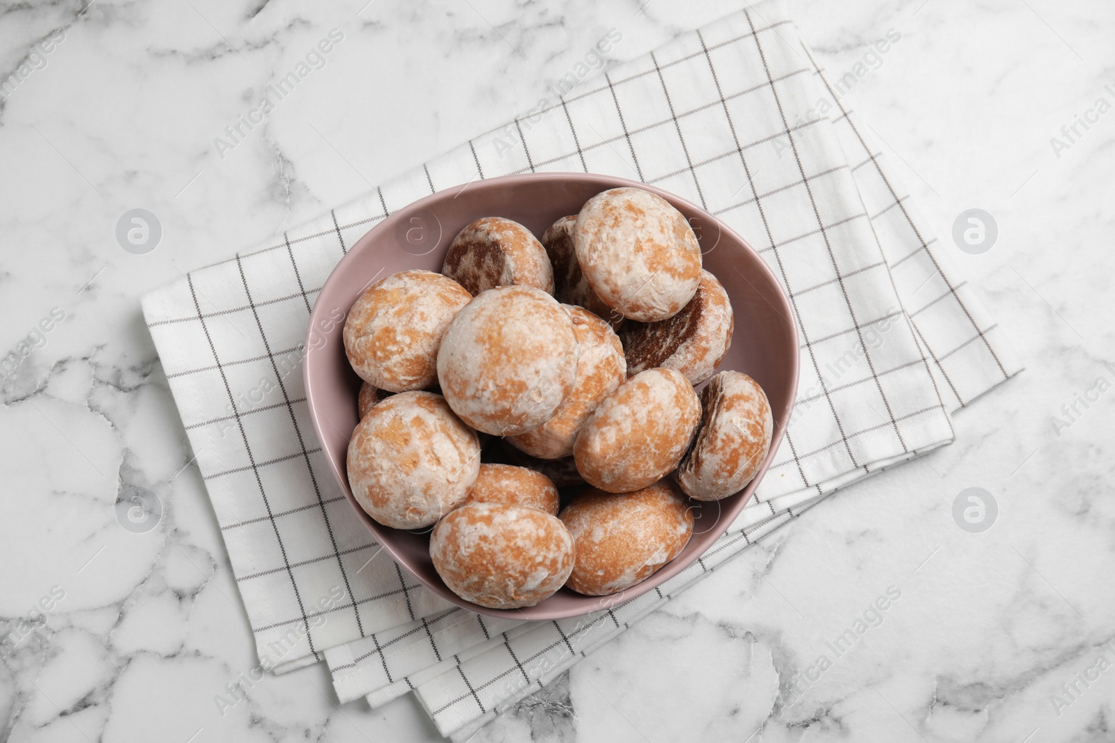 Photo of Tasty homemade gingerbread cookies in bowl on white marble table, top view