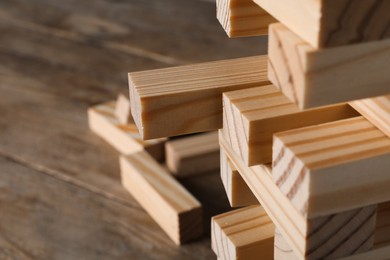 Photo of Jenga tower made of wooden blocks on table, closeup. Space for text
