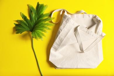 Flat lay composition with eco tote bag and leaf on color background