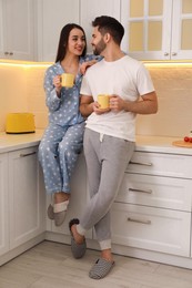 Happy couple in pajamas having breakfast at home