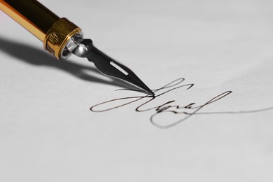 Photo of Signing on sheet of paper with fountain pen, closeup