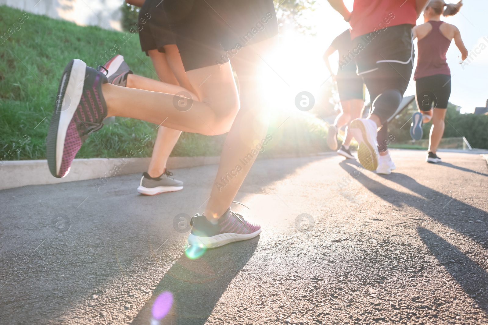 Photo of Group of people running outdoors on sunny day, closeup