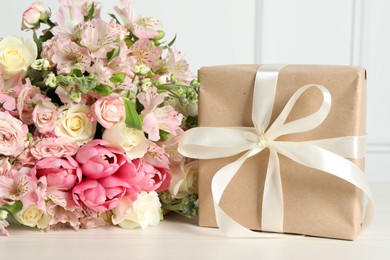 Happy Mother's Day. Gift box and bouquet of beautiful flowers on white table