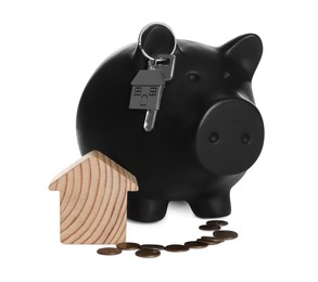 Photo of Piggy bank with key, house model and coins on white background. Saving money concept