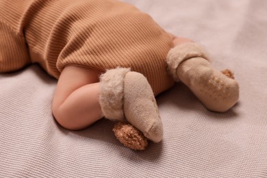 Photo of Newborn baby lying on brown blanket, closeup
