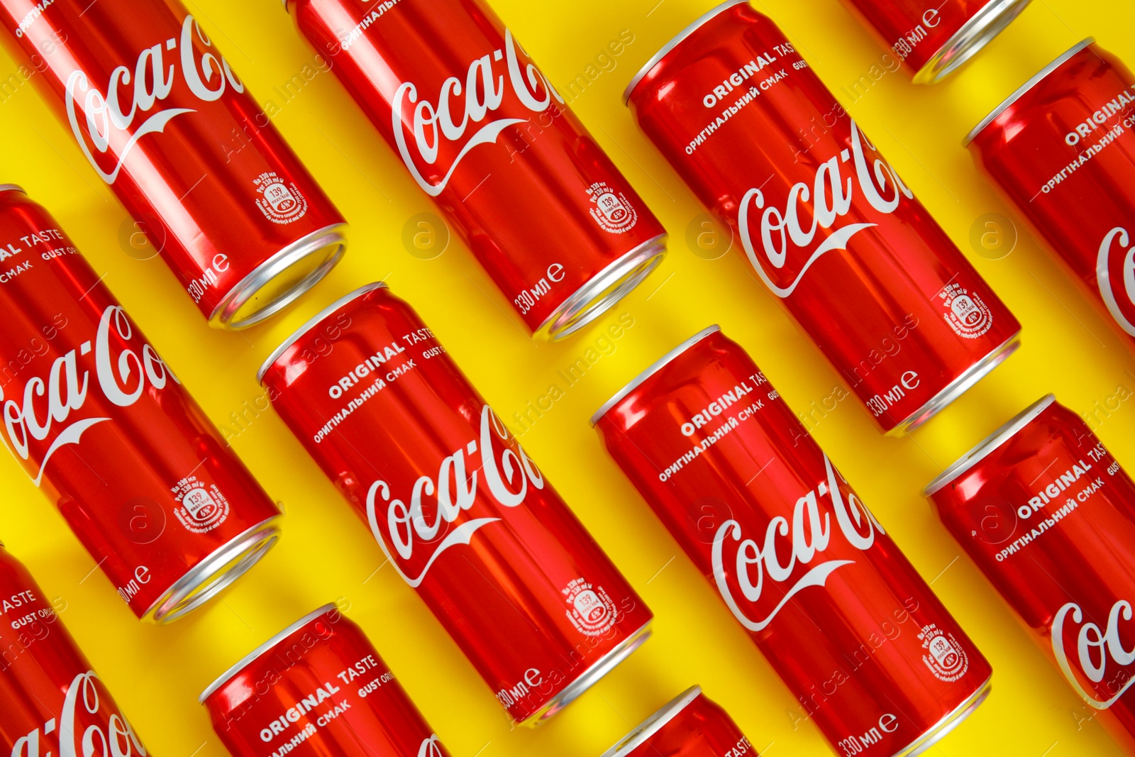 Photo of MYKOLAIV, UKRAINE - NOVEMBER 14, 2018: Coca-Cola cans on color background, flat lay