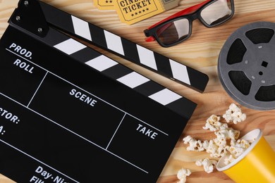 Photo of Flat lay composition with clapperboard and 3D glasses on wooden table