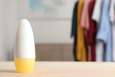 Roll-on deodorant on table against blurred background. Space for design