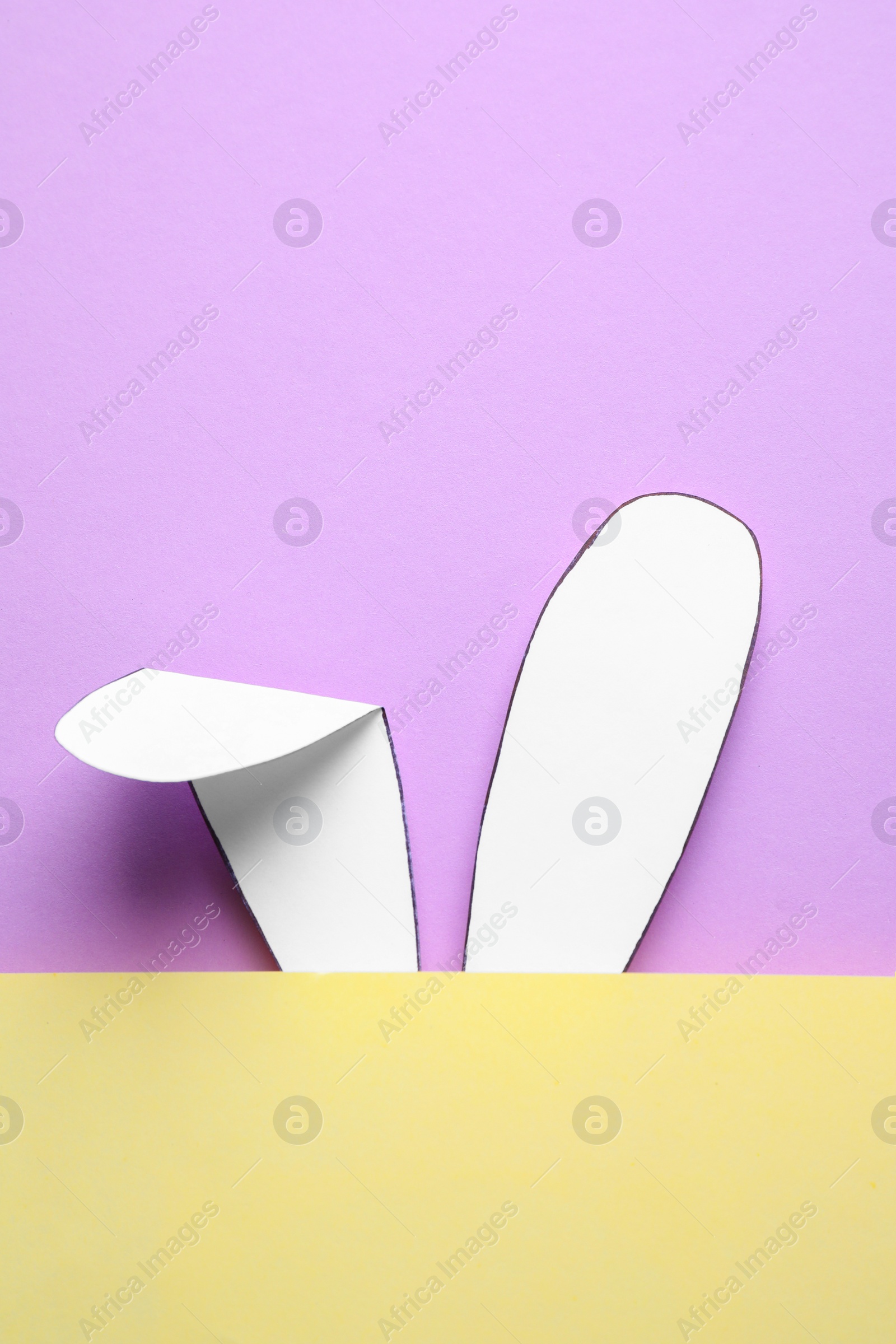 Photo of Top view of paper bunny ears on pale violet  background, space for text. Easter celebration