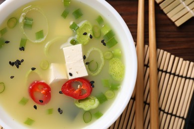 Bowl of delicious miso soup with tofu served on table, top view