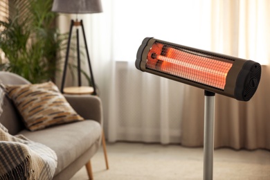 Photo of Modern electric infrared heater at home. Space for text