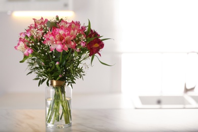 Photo of Vase with beautiful alstroemeria flowers on table in kitchen, space for text. Interior design