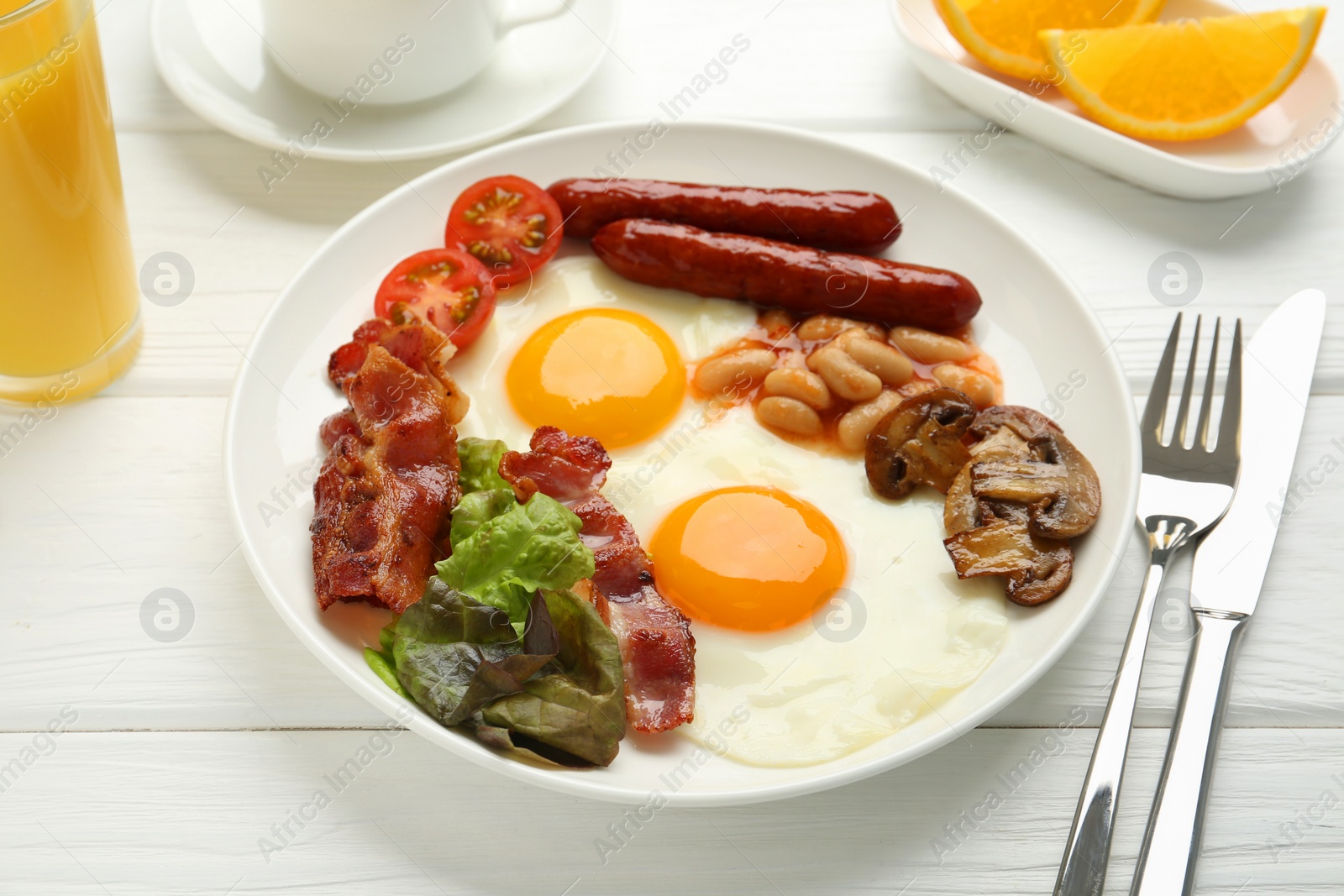 Photo of Delicious breakfast with sunny side up eggs served on white wooden table, closeup