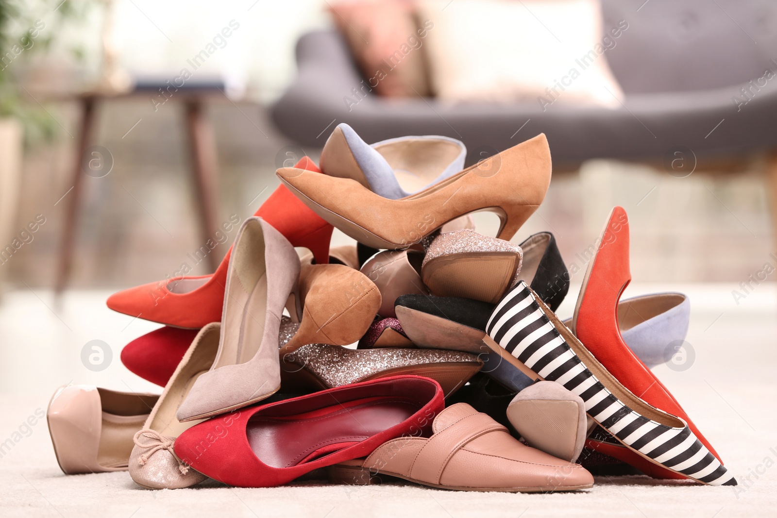 Photo of Heap of different shoes on floor in room