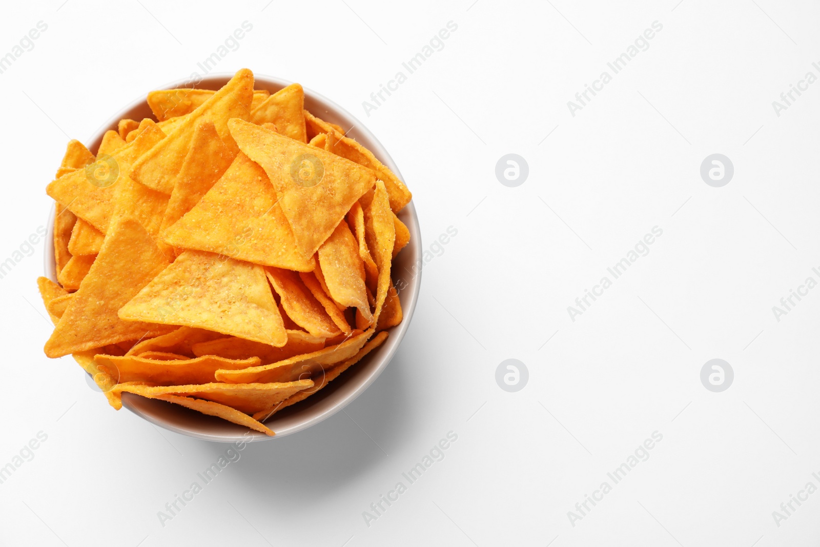 Photo of Tortilla chips (nachos) in bowl on white background, top view