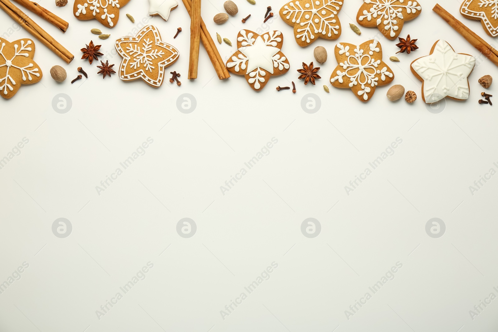 Photo of Tasty Christmas cookies with icing and spices on white background, flat lay. Space for text