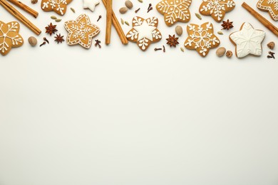 Tasty Christmas cookies with icing and spices on white background, flat lay. Space for text